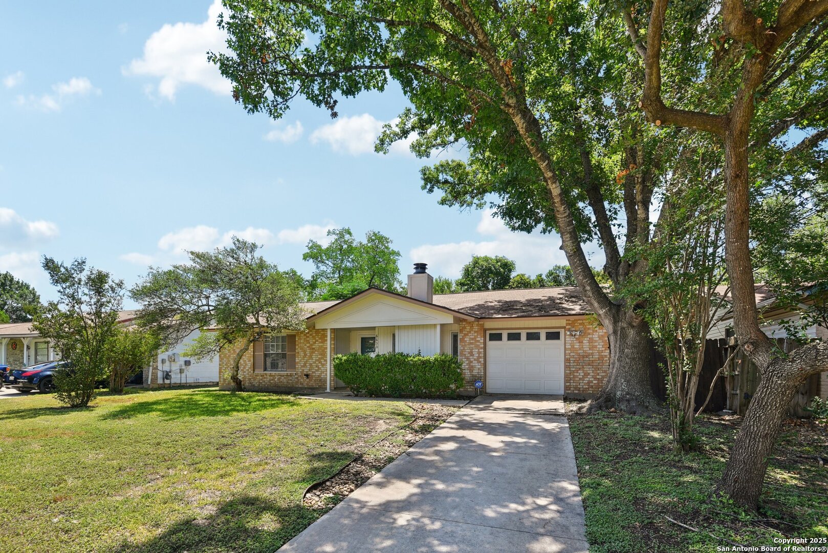6630 Spring Hollow Street San Antonio, TX 78249 - Photo 3 of 40 a front view of a house with a yard and garage