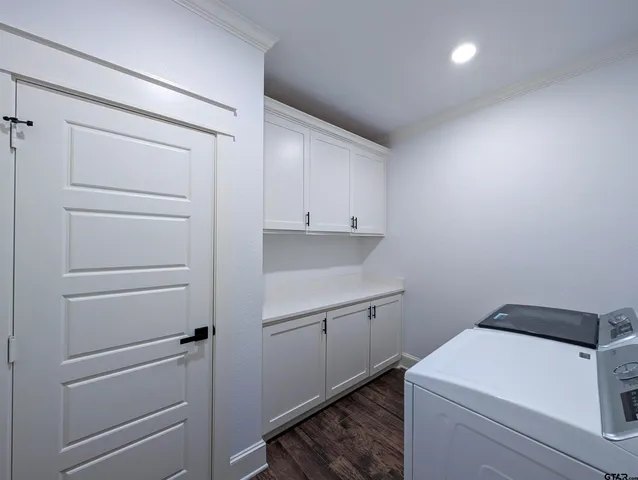 a utility room with cabinets washer and dryer