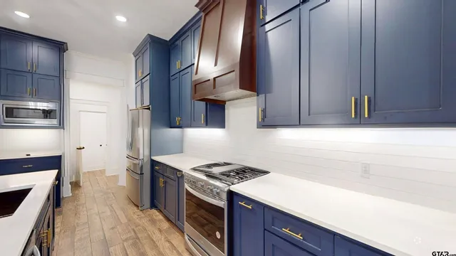 a kitchen with stainless steel appliances granite countertop a stove a sink and a refrigerator