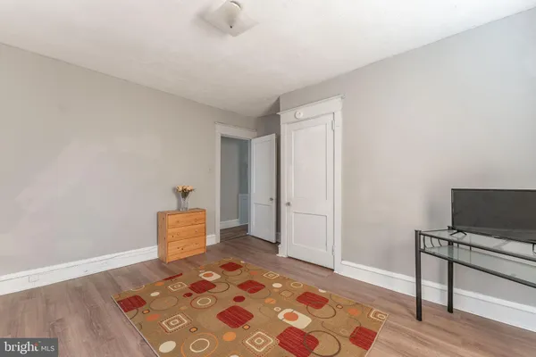 a bedroom with a bed and a lamp with wooden floor