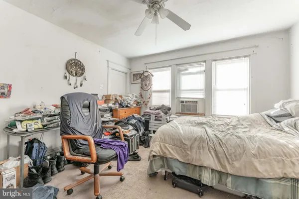 a bedroom with bed a chair and a chandelier