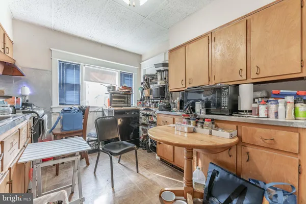 a kitchen with a dining table chairs and a refrigerator