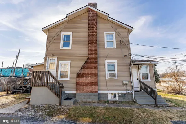 a view of a house with a yard and wooden deck
