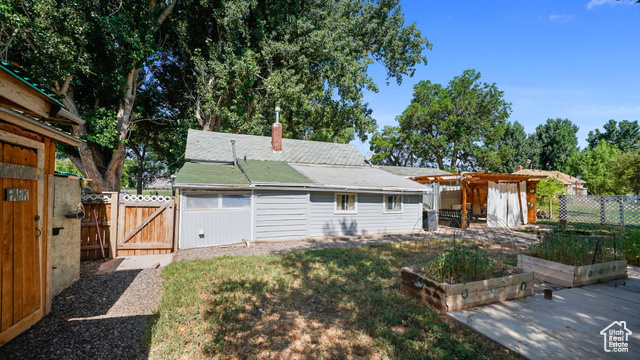 180 North State Street Sigurd, UT 84657 - Photo 5 of 32 Back of property with a vegetable garden, a gate, a chimney, a fenced backyard, and a pergola