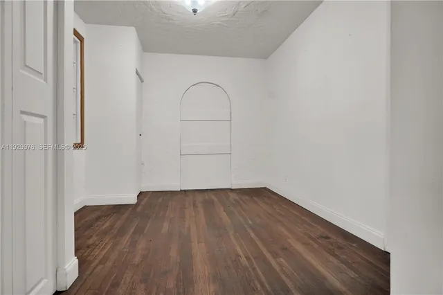 a view of a room with wooden floor and white walls