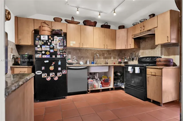 a kitchen with stainless steel appliances granite countertop a refrigerator a sink and a stove