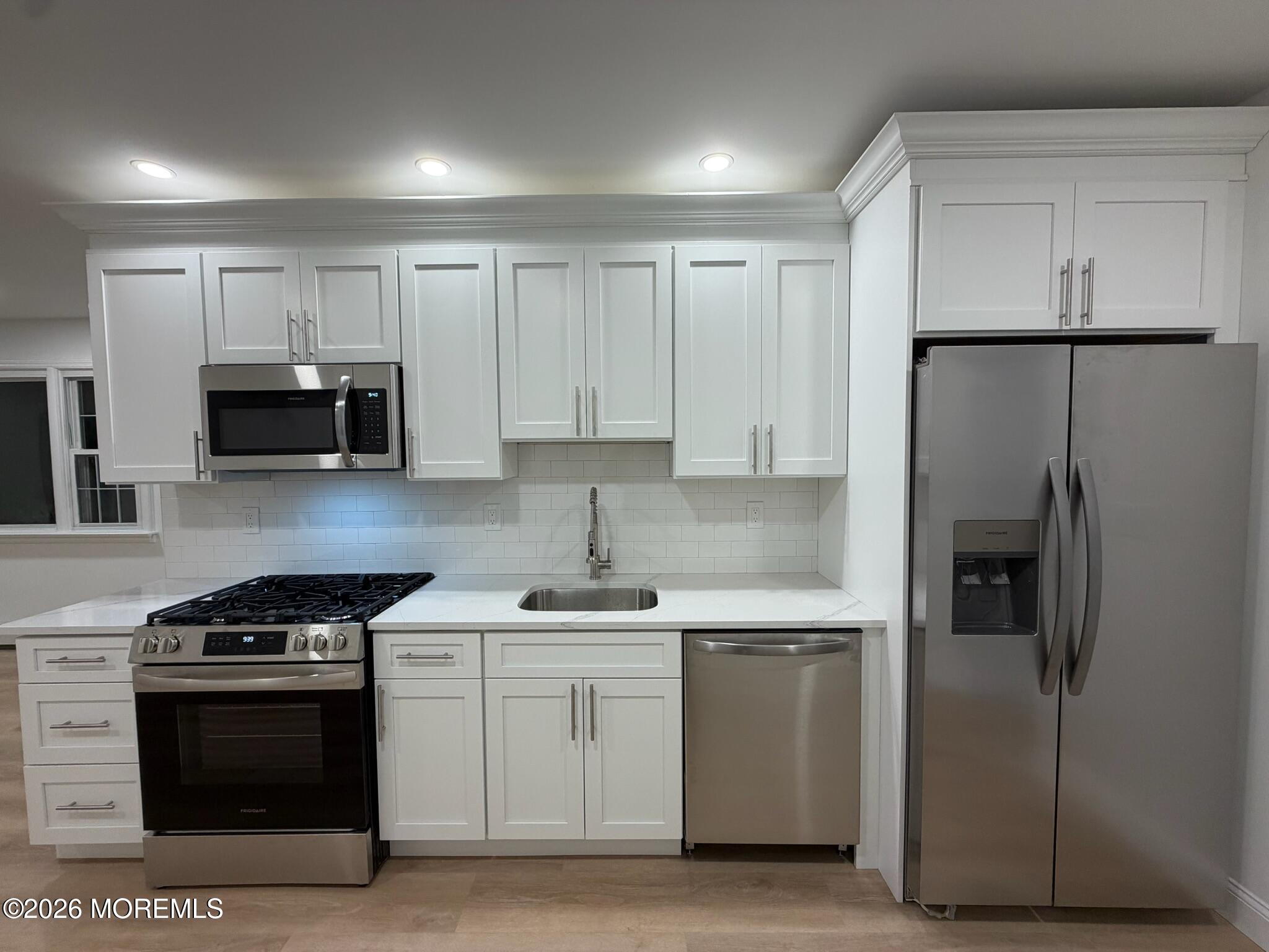 13 Pittenger Pond Road Freehold, NJ 07728 - Photo 7 of 16 a kitchen with stainless steel appliances a stove a sink and a refrigerator