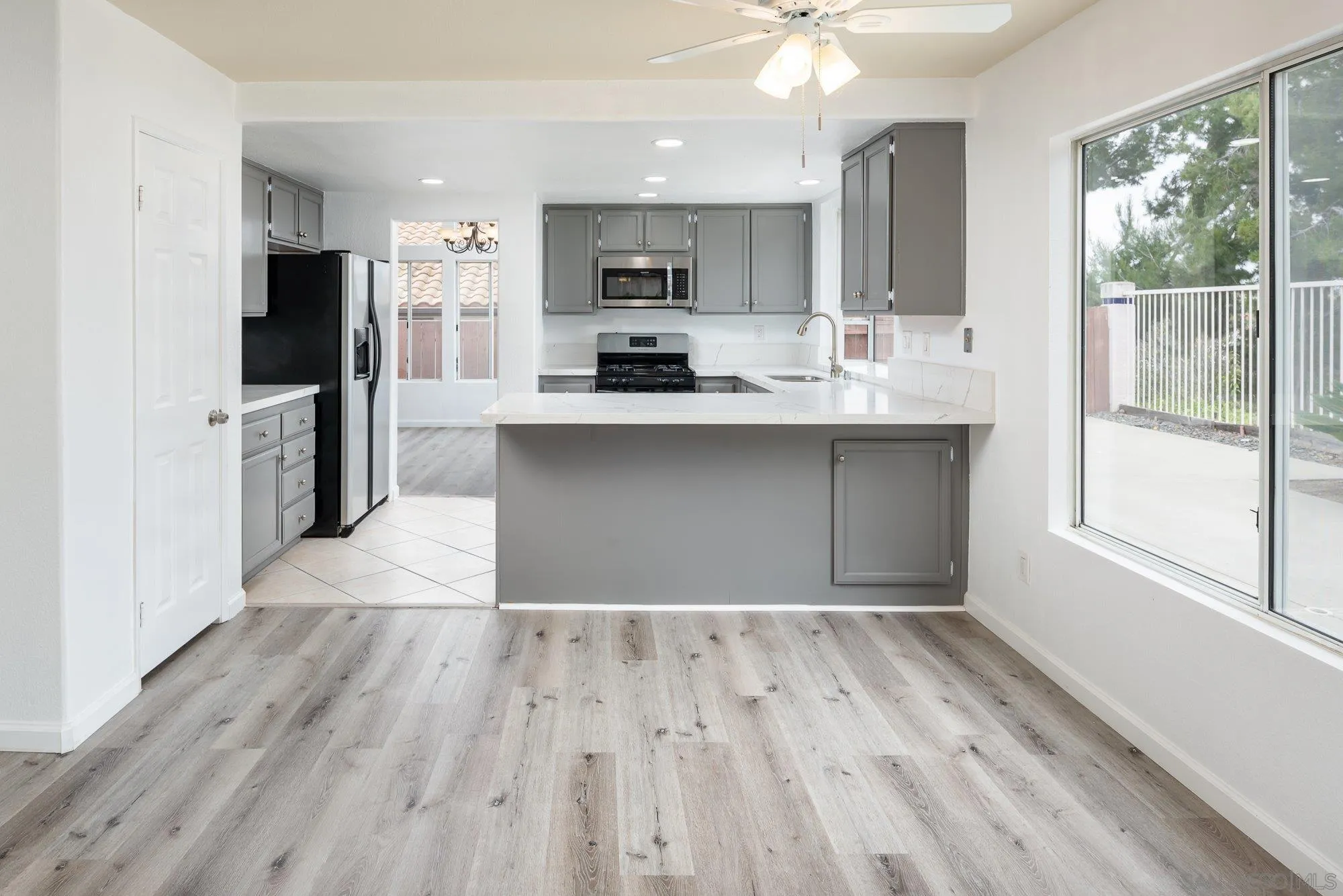 665 Montage Road Oceanside, CA 92057 - Photo 18 of 52 a kitchen with wooden floors stainless steel appliances a window and a counter space