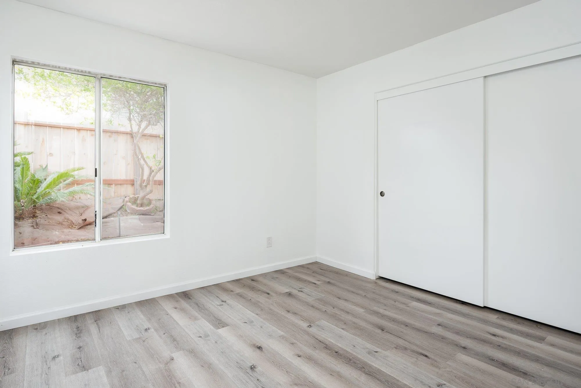 665 Montage Road Oceanside, CA 92057 - Photo 24 of 52 an empty room with wooden floor and windows