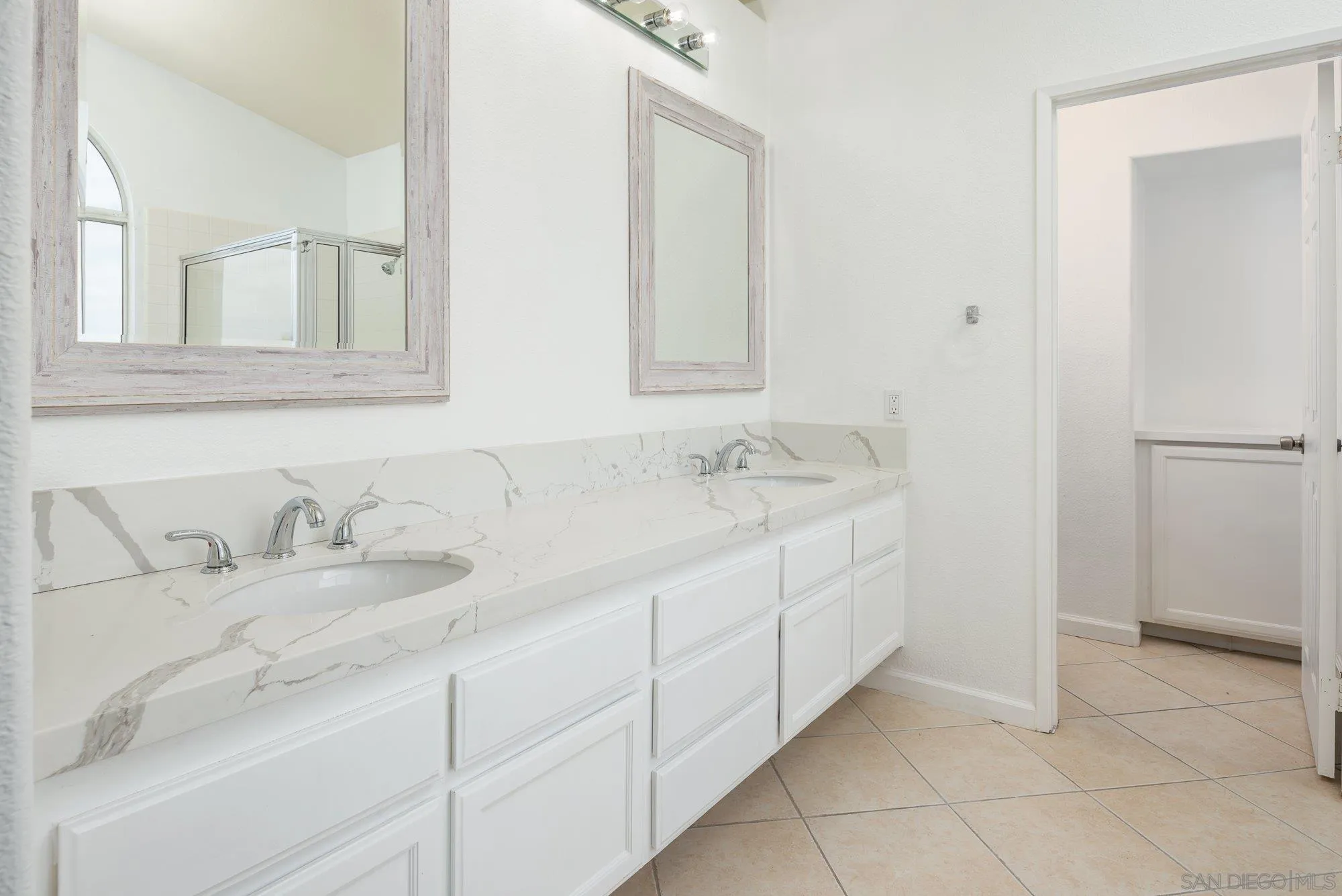665 Montage Road Oceanside, CA 92057 - Photo 32 of 52 a bathroom with a double vanity sink and a mirror