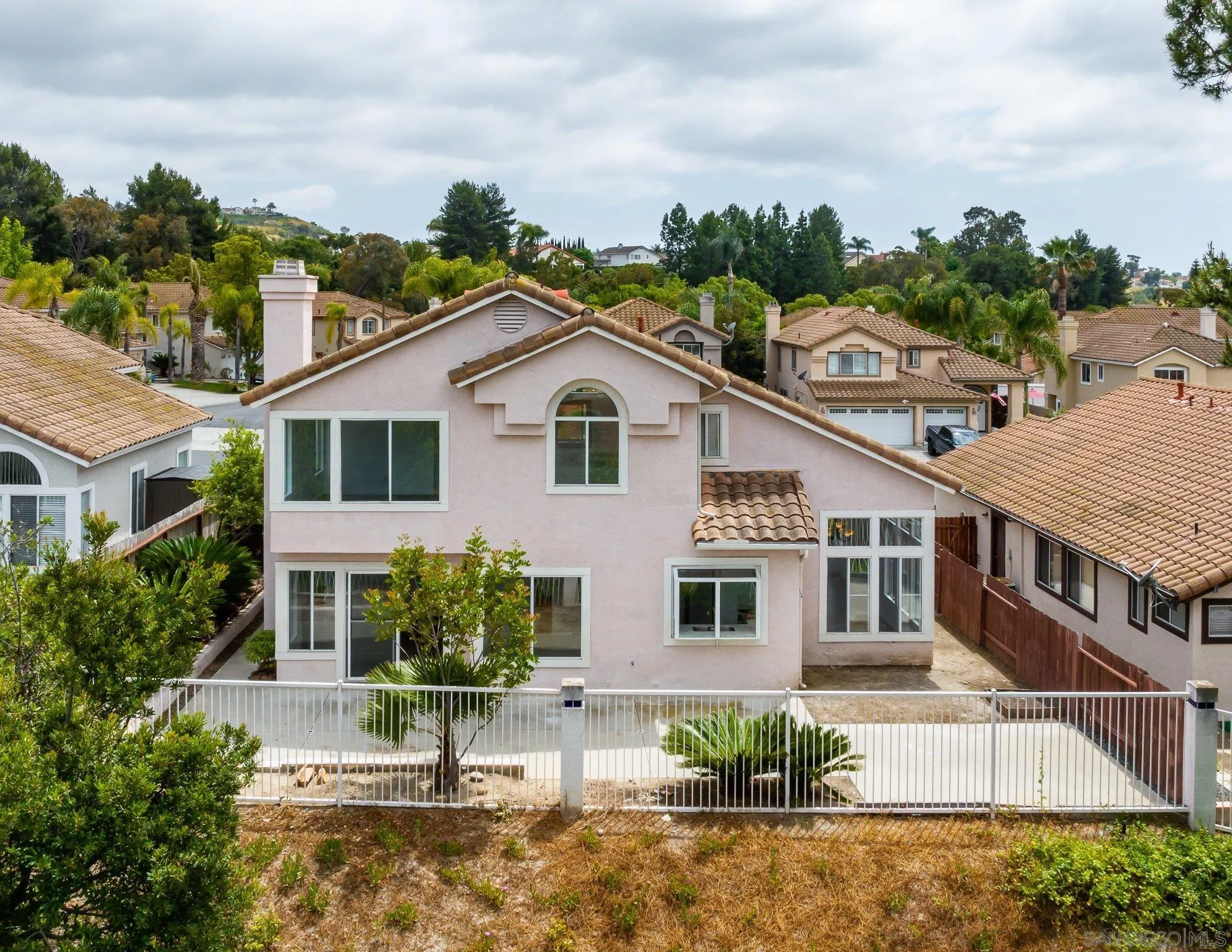 665 Montage Road Oceanside, CA 92057 - Photo 4 of 52 a view of a white house next to a yard with potted plants