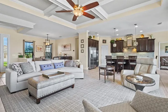 a living room with furniture kitchen view and a chandelier