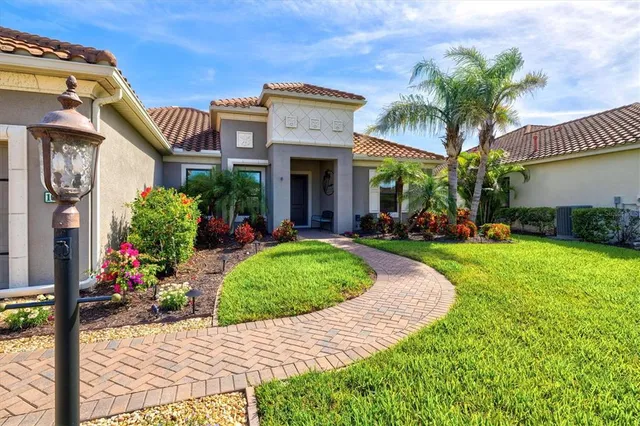 a front view of a house with a yard and potted plants