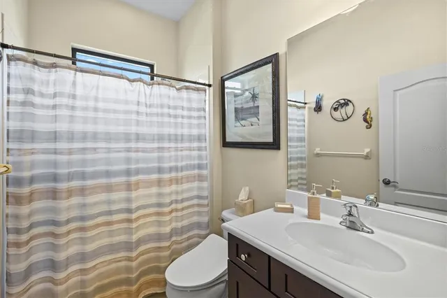 a bathroom with a sink a toilet and shower curtain