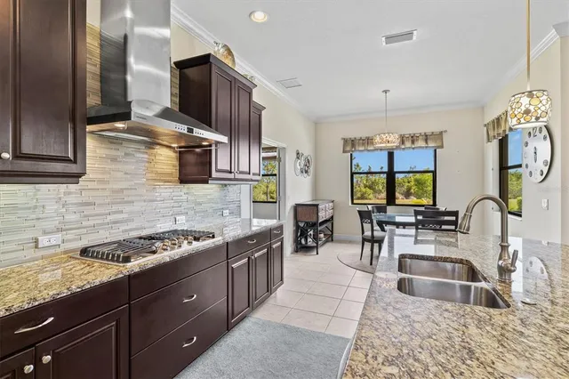 a kitchen with stainless steel appliances granite countertop a sink stove and cabinets