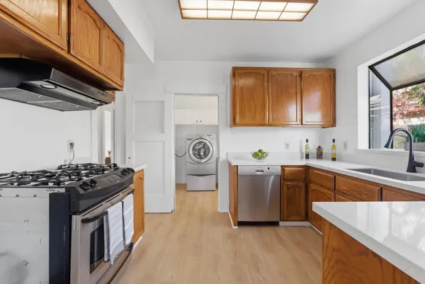 a kitchen with stainless steel appliances granite countertop a stove a sink dishwasher and a refrigerator