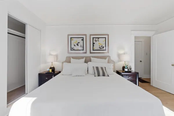 a bedroom with a bed and a painting on the wall