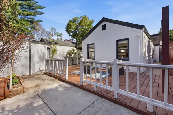 a view of a house with large windows and wooden fence