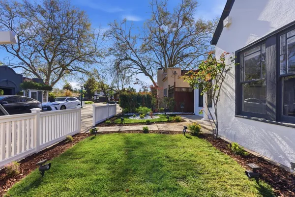 a view of a house with backyard and a tree