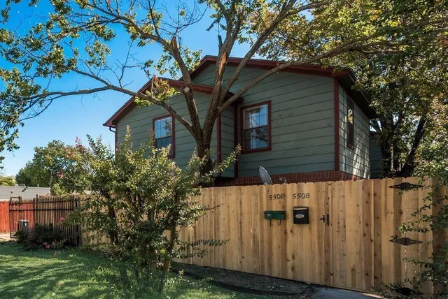 a view of a wooden house with a tree