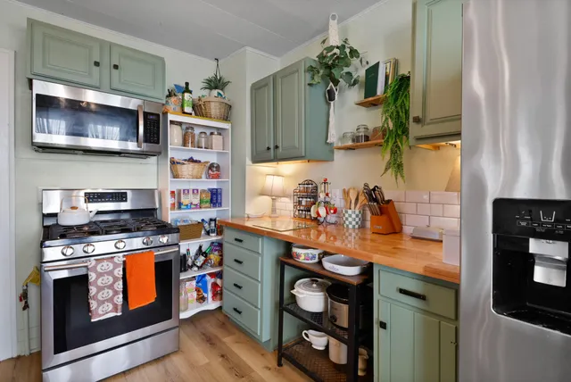a kitchen with stainless steel appliances a stove a sink and a microwave