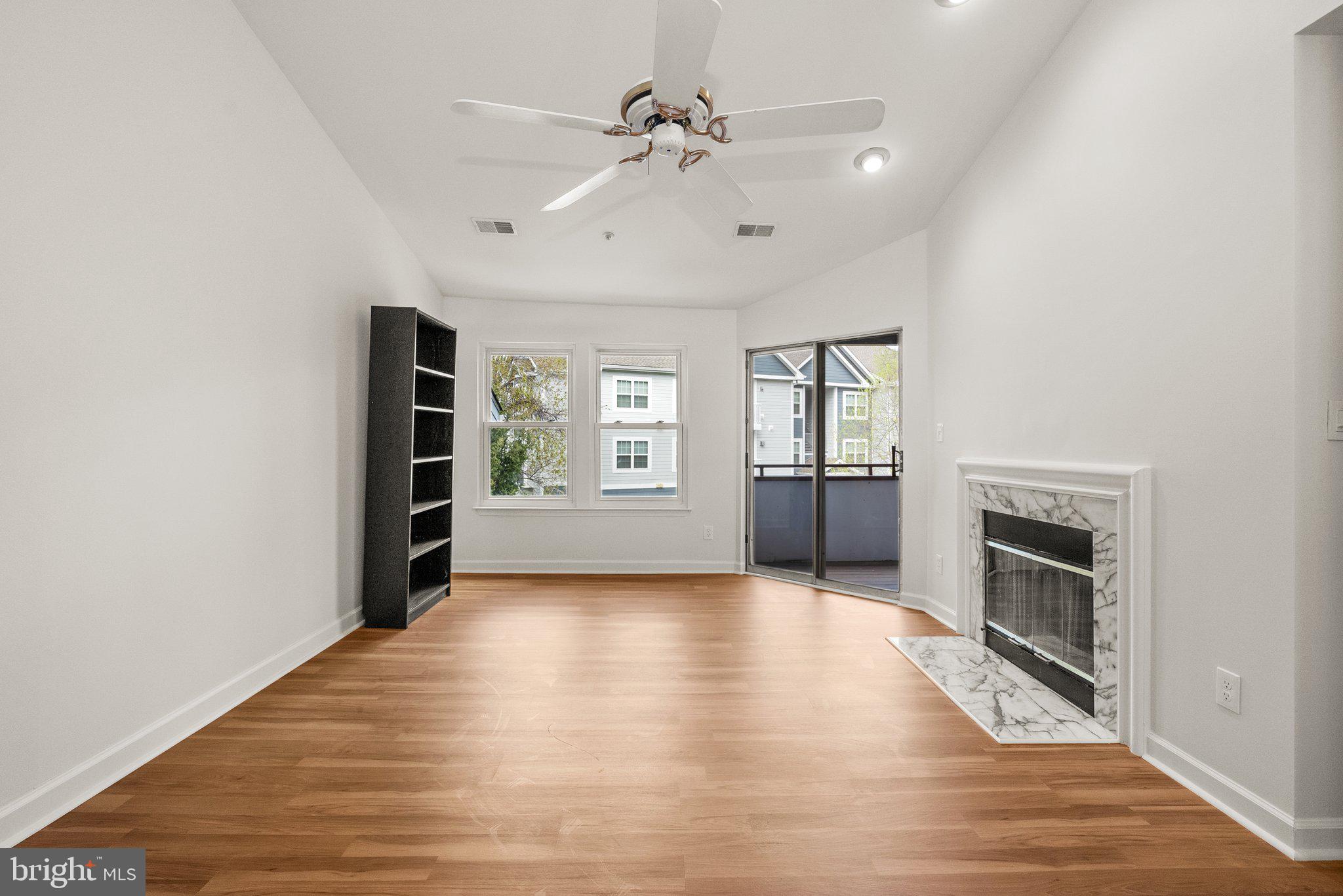 3301 Sir Thomas Drive, Unit 6B41 Silver Spring, MD 20904 - Photo 13 of 27 wooden floor in an empty room with a fireplace and a window