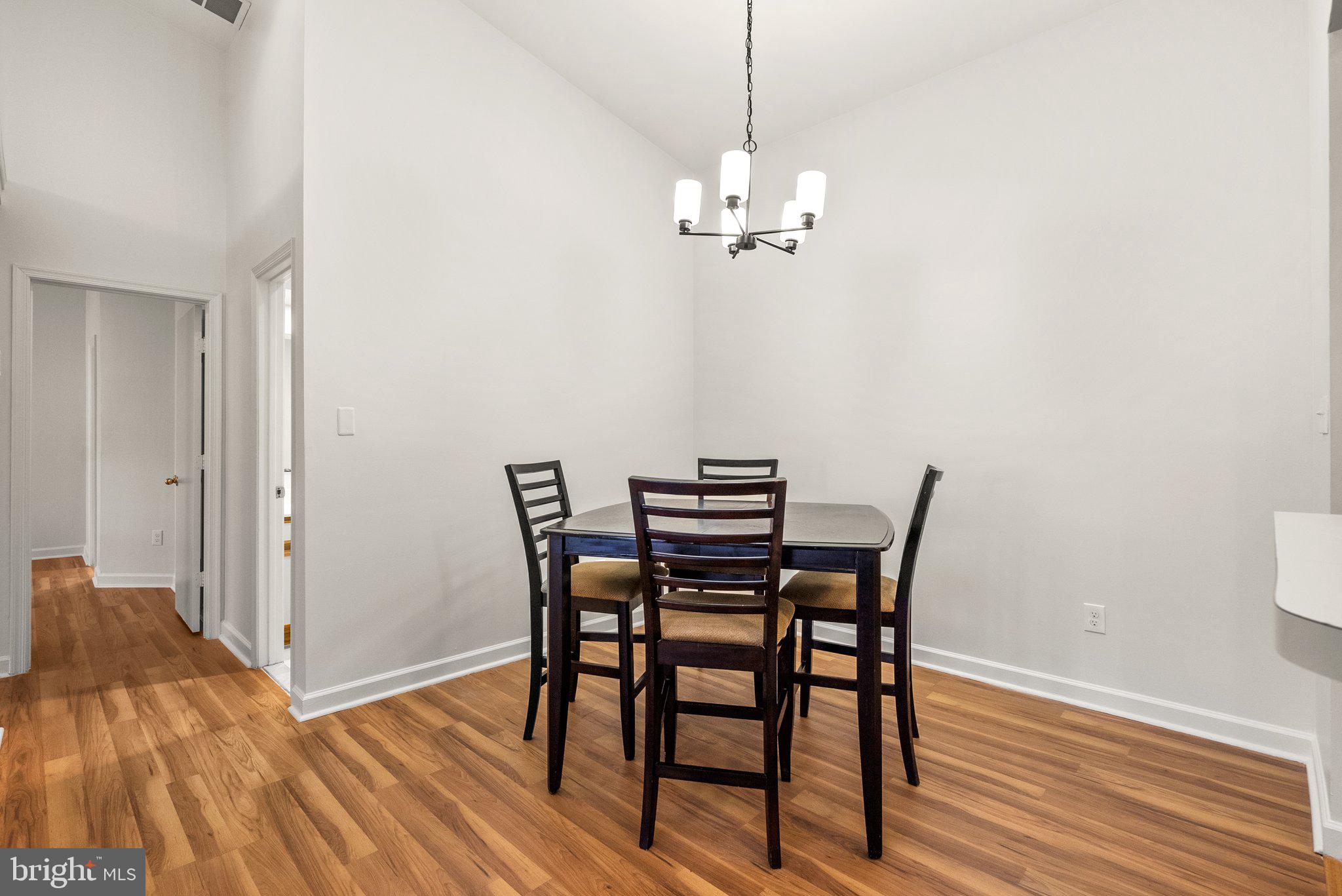 3301 Sir Thomas Drive, Unit 6B41 Silver Spring, MD 20904 - Photo 17 of 27 a view of a dining room with furniture wooden floor and chandelier