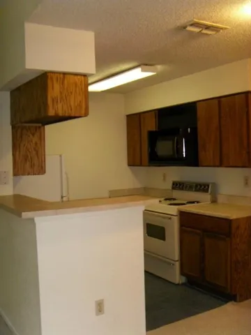 a kitchen with a sink and a stove top oven with wooden floor