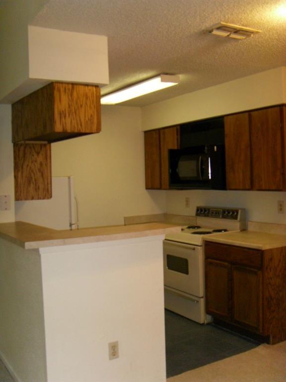 114 East 31st Street, Unit 206 Austin, TX 78705 - Photo 4 of 9 a kitchen with a sink and a stove top oven with wooden floor