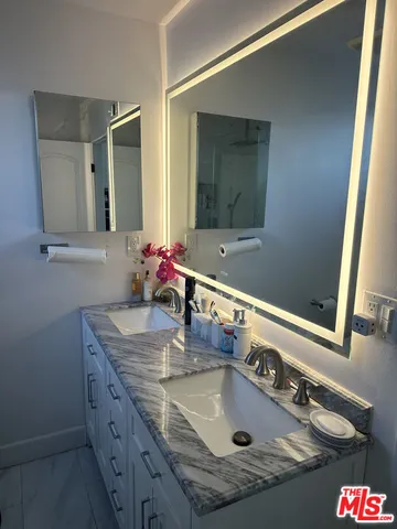 a bathroom with a granite countertop sink and a mirror
