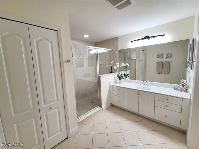 a bathroom with a double vanity sink a mirror and a shower