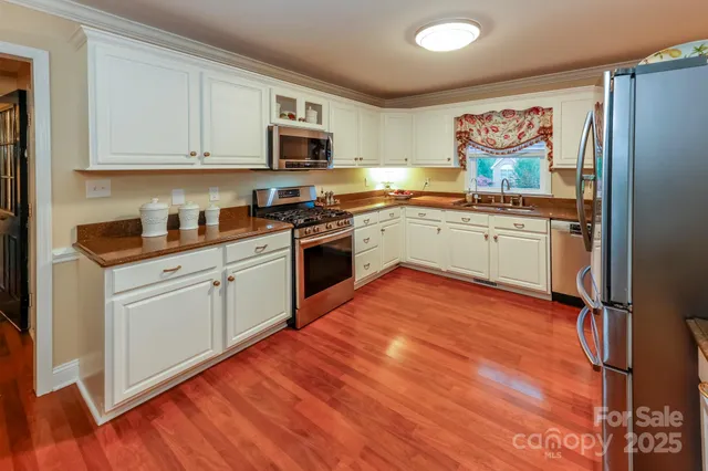 a kitchen with stainless steel appliances granite countertop a stove top oven and cabinets