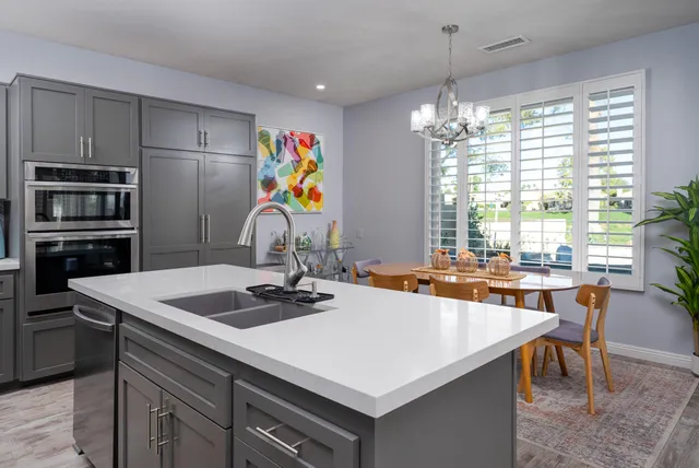 a kitchen with a sink a stove and chairs