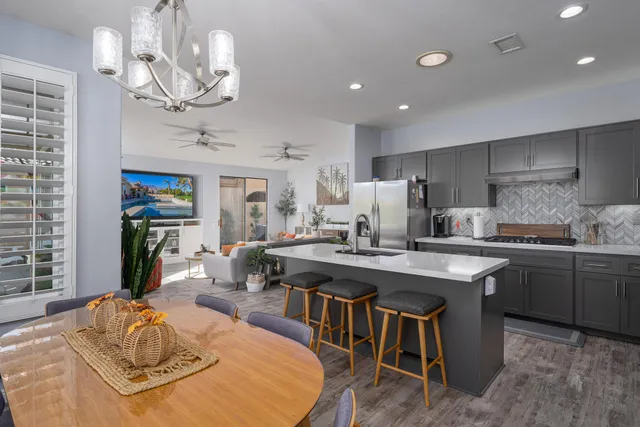 a kitchen with stainless steel appliances granite countertop a sink and a refrigerator