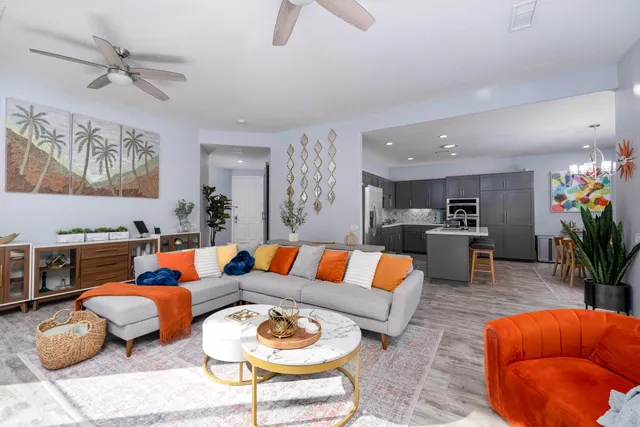 a living room with furniture kitchen view and a potted plant