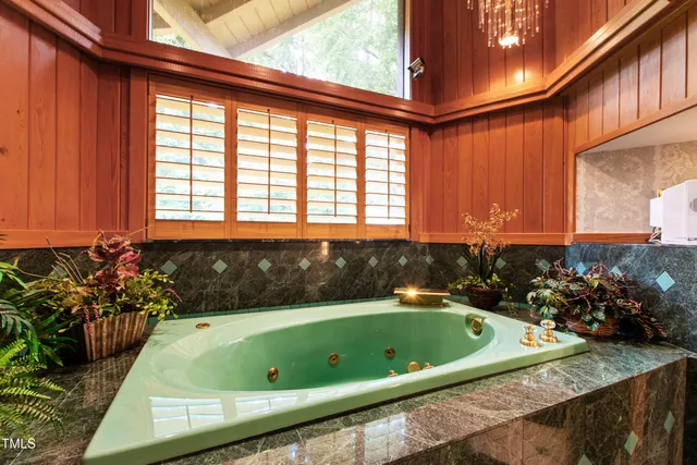 a view of a livingroom with furniture a fireplace and large windows