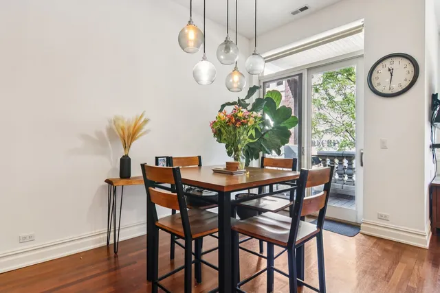 a dining room with furniture a large window and wooden floor
