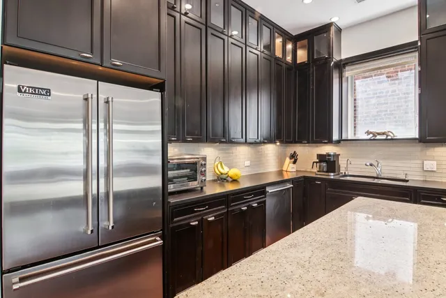 a kitchen with kitchen island granite countertop stainless steel appliances and sink