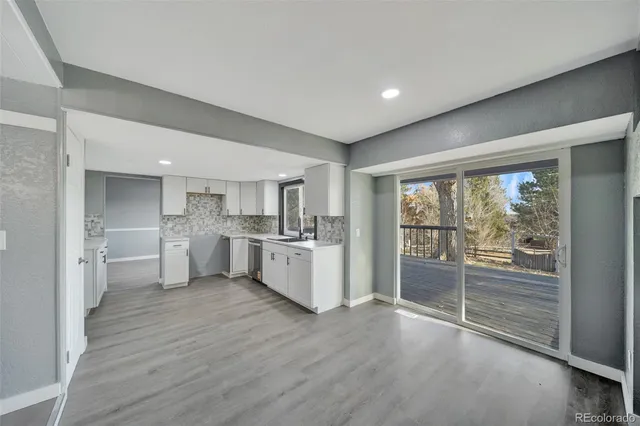 a large white kitchen with sink and cabinets