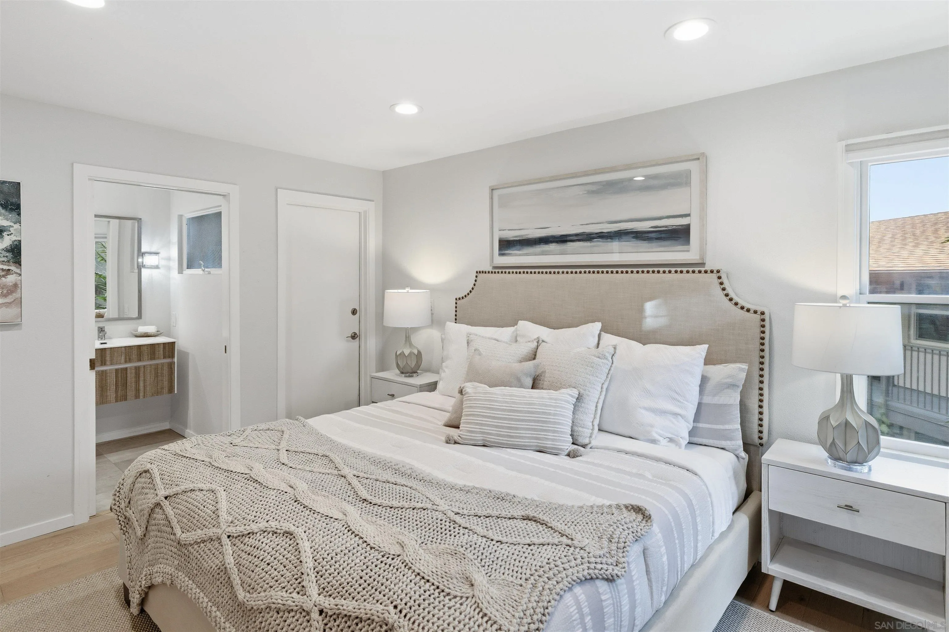 940 Sealane Drive, Unit 5 Encinitas, CA 92024 - Photo 12 of 48 a bedroom with a bed and a lamp