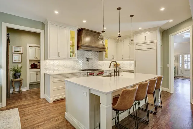 a kitchen with stainless steel appliances granite countertop a stove a sink and a refrigerator