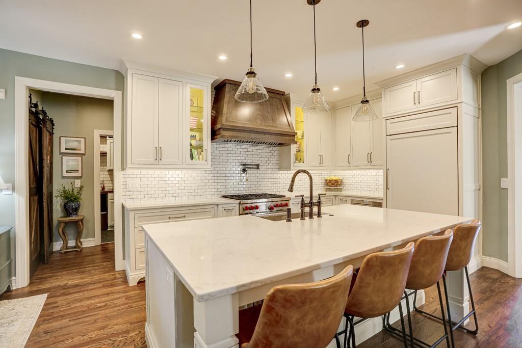 3805 Pennington Road Cumming, GA 30041 - Photo 19 of 63 a kitchen with kitchen island a stove a table a sink refrigerator and cabinets