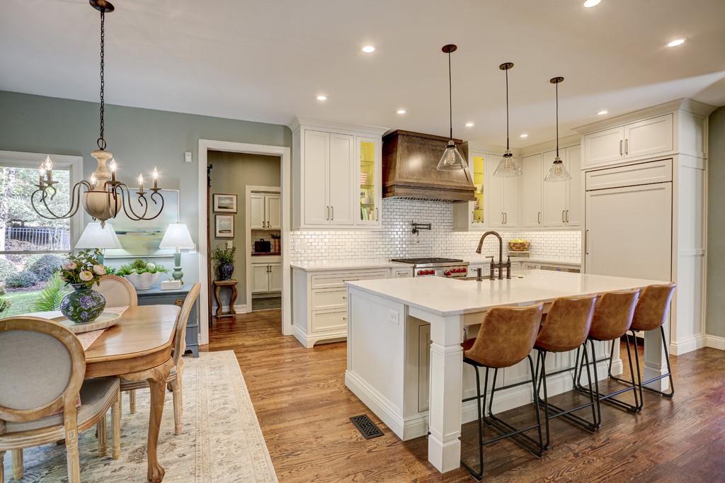 3805 Pennington Road Cumming, GA 30041 - Photo 20 of 63 a kitchen with stainless steel appliances granite countertop a sink a stove a refrigerator cabinets and chairs