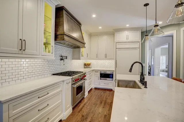 a kitchen with stainless steel appliances granite countertop a stove a refrigerator a oven a sink with a dining table and chairs