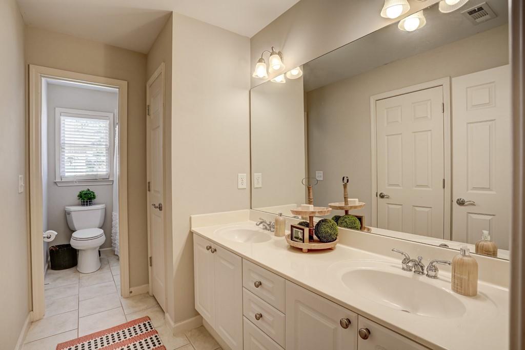 3805 Pennington Road Cumming, GA 30041 - Photo 53 of 63 a spacious bathroom with a double vanity sink toilet and a mirror