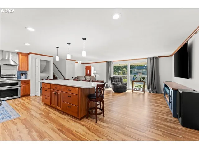 a kitchen with stainless steel appliances kitchen island granite countertop a stove a sink and a microwave