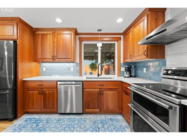a kitchen with stainless steel appliances granite countertop a refrigerator and a sink