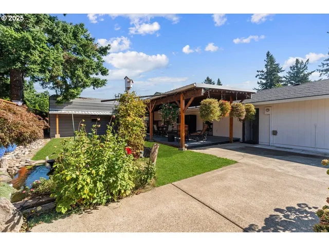 a view of a house with a yard and potted plants