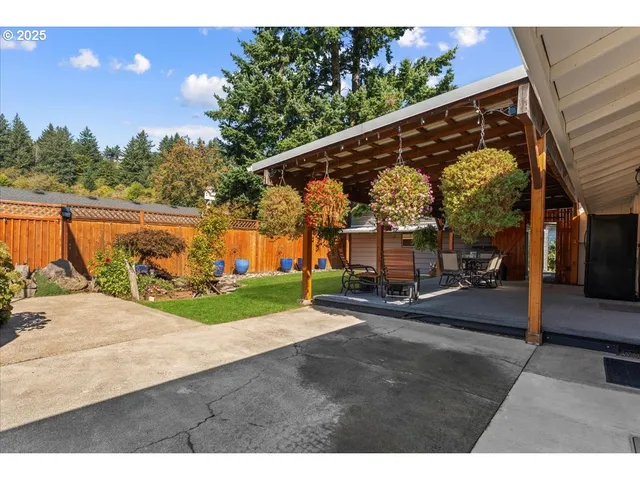 a view of a patio with table and chairs under an umbrella with a tree