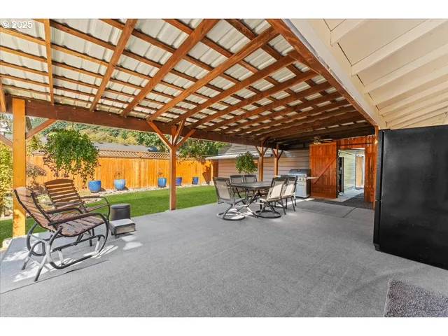 a view of a patio with table and chairs with wooden floor and fence
